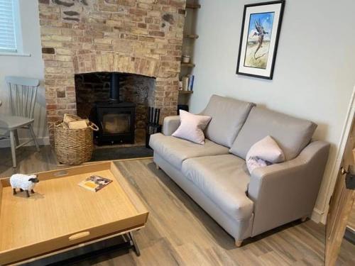 a living room with a couch and a fireplace at Little House in Porlock