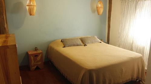 1 dormitorio con 1 cama con 2 almohadas en CASA TUPI, en Ubatuba