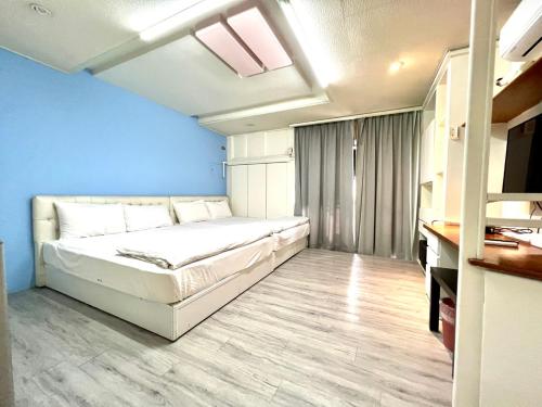 a bedroom with a bed and a blue wall at Long house in Taichung