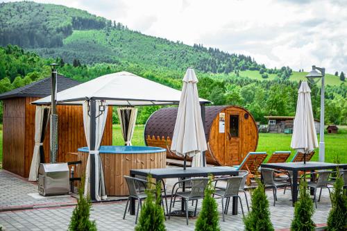 a group of tables and umbrellas on a patio at Pensiunea ARC Bucovina in Vama