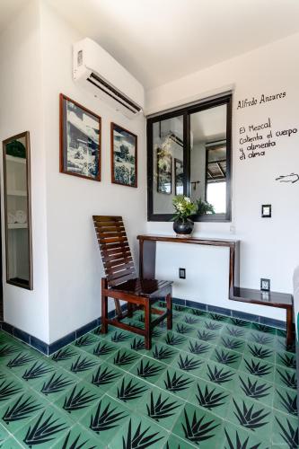 a room with a table and a chair on a green floor at Cabane Container Hotel - ADULTS ONLY in Puerto Escondido