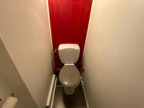 un bagno con servizi igienici e pareti rosse di Le charme Rouennais - Appartement d'exception - 094 a Rouen