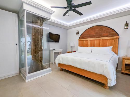 a bedroom with a large bed and a glass door at Hacienda Valentino in San Cristóbal de Las Casas