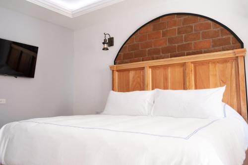 a bedroom with a bed with a brick wall at Hacienda Valentino in San Cristóbal de Las Casas
