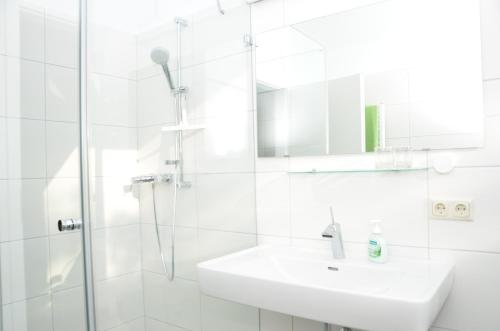 y baño blanco con lavabo y ducha. en Natur.gut Gartner, en Sankt Marien
