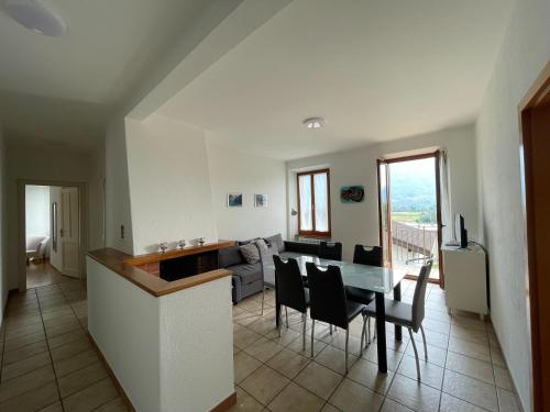 eine Küche und ein Wohnzimmer mit einem Tisch und Stühlen in der Unterkunft Residence Gaggiole, apartment 3 in Gordola