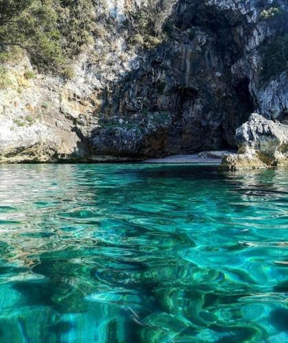 a large body of blue water next to a cliff at LIMNIONAS SUNVIEW in Xorychti