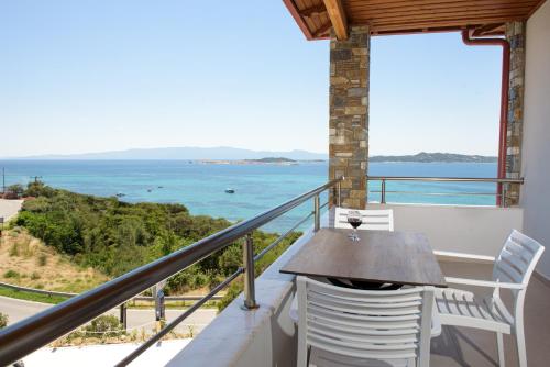 un balcone con tavolo e sedie e l'oceano di PANORAMA ROOM APARTMENs a Ouranoupoli