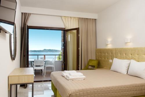 a bedroom with a bed with a view of the ocean at PANORAMA ROOM APARTMENs in Ouranoupoli