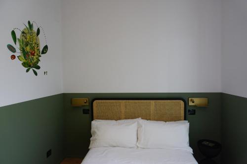 uma cama com almofadas brancas e um relógio na parede em Casa Floris em San Benedetto del Tronto