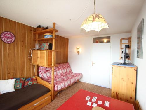 a living room with a couch and a shelf at Studio Chamrousse, 1 pièce, 4 personnes - FR-1-549-75 in Chamrousse