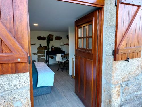 a door to a room with a bed and a desk at Quinta da Ponte in Viana do Castelo