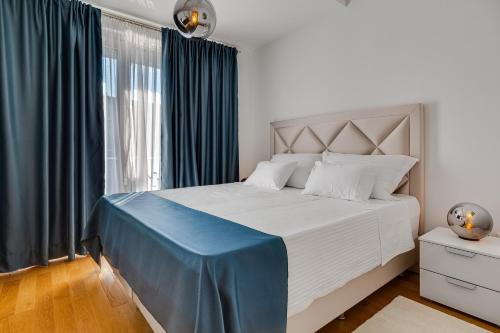 a bedroom with a large bed with a blue blanket on it at Diamond two bedroom apartment in Zadar