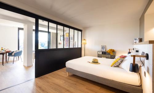 ラ・ガシイにあるLa Bergerie Yves Rocherのベッドルーム(大きな白いベッド1台、テーブル付)