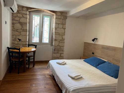 a bedroom with a bed and a table and a window at The Heart of Hvar in Hvar