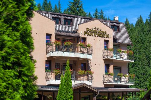 a building with flower boxes on the balconies at Pension Pantheon in Poiana Brasov