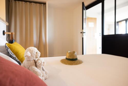 two stuffed animals sitting on top of a bed at La Bergerie Yves Rocher in La Gacilly