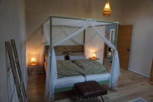 ein Schlafzimmer mit einem Himmelbett und zwei Lampen in der Unterkunft Alte Brennerei Schloss Zehista OG Akelei in Pirna