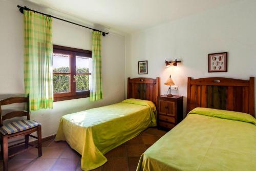 sypialnia z dwoma łóżkami i oknem w obiekcie Villa Amorós w Cala Ratjada