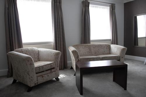 a living room with two chairs and a coffee table at Lion Hotel in Worksop