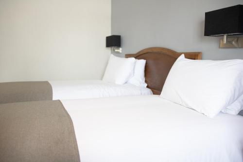 two beds in a hotel room with white pillows at Lion Hotel in Worksop