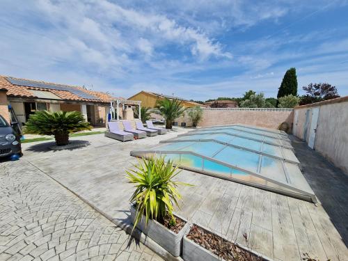 una piscina en un patio con una casa en Ni 100%Gite,Ni100% loc chez Kheira&Pascal en Vitrolles