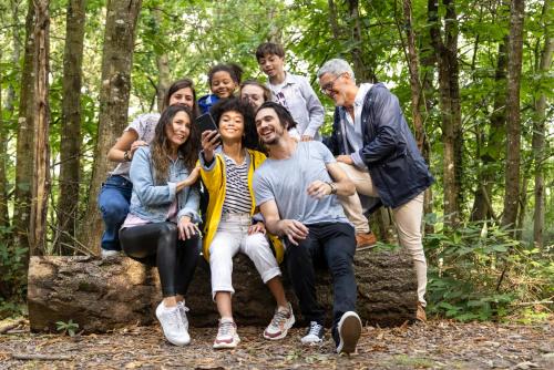 a group of people sitting on a rock in the woods at La Bergerie Yves Rocher in La Gacilly