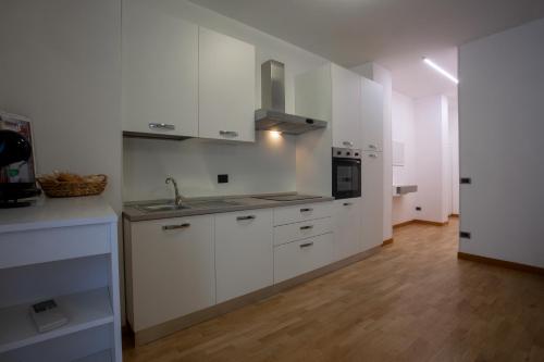 una cocina blanca con armarios blancos y fregadero en Casa vacanze san salvo centro en San Salvo