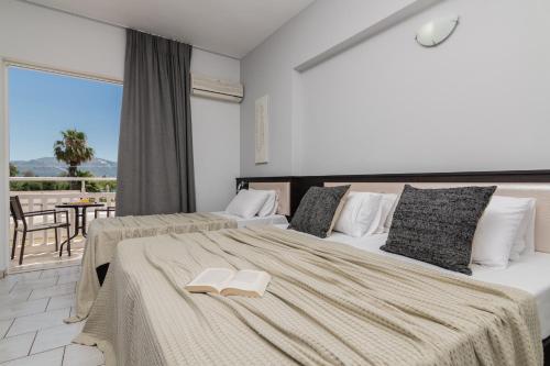 a hotel room with two beds and a balcony at Rivulet Apartments in Laganas