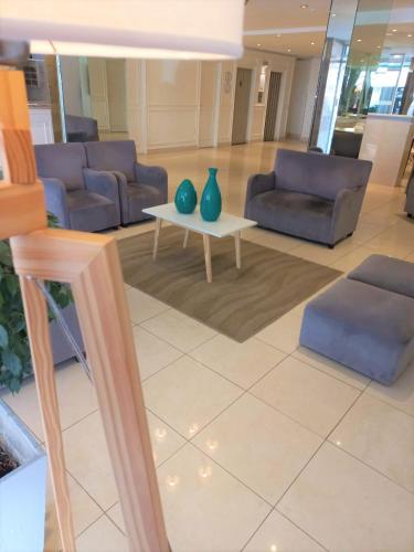 a lobby with couches and a table with vases on it at Hotel Vip´s in Mar del Plata