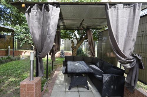 a patio with a couch and a table under a canopy at Vila Sofia in Costinesti