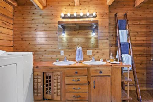 a bathroom with two sinks and a wooden wall at Fun fishing river cabin 23mi to beach with private dock 3BD 2BA in Youngstown