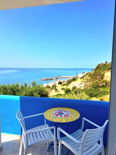 a table and chairs on a balcony with a view of the ocean at Panorama Melina Apartments in Kastrí
