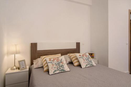 un letto con due cuscini sopra in una camera da letto di Sunshine Apartment ad Armação de Pêra