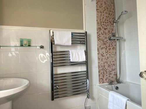a bathroom with a shower and a sink and a toilet at Virginia Court Hotel in Cromer