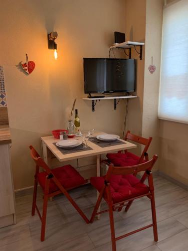 d'une salle à manger avec une table, deux chaises et une télévision. dans l'établissement Houssen/Colmar: « Chez Lin’Doux », le Nid Alsacien, à Houssen