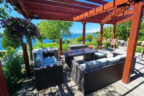 a pergola with chairs and tables on a patio at Grandview Motel in Tobermory