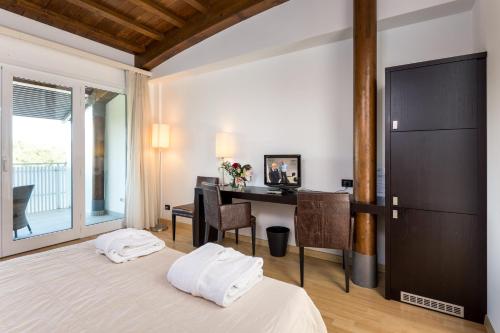 una camera con letto, scrivania e tavolo di Hotel Smeraldo a Lignano Sabbiadoro
