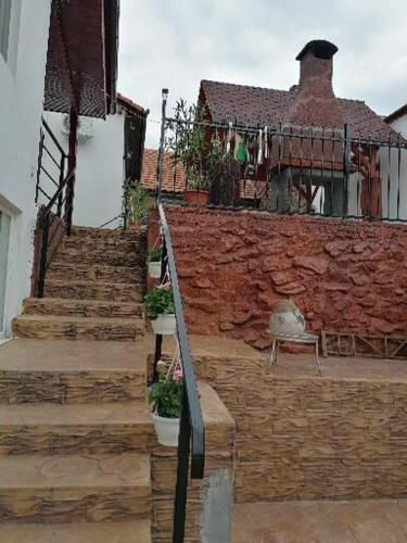 a building with stairs and a brick wall with a balcony at La Colette in Dubova