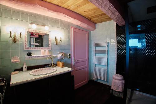 baño con puerta rosa y lavamanos en DOL' IN LOVE Love room BDSM 4 étoiles en Dol-de-Bretagne