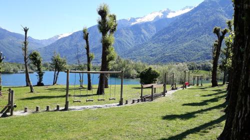 a park with trees and a lake and mountains at Chambre d'hotes le cycliste in La Chapelle