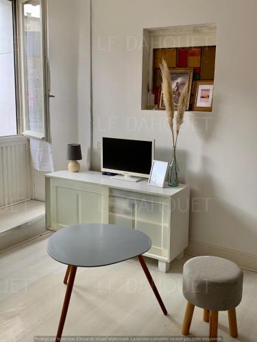 Cette chambre comprend un bureau avec un ordinateur et une chaise. dans l'établissement Joli studio avec terrasse à deux pas de la plage, à Pléneuf-Val-André