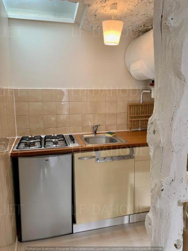 une petite cuisine avec un évier et une cuisinière dans l'établissement Joli studio avec terrasse à deux pas de la plage, à Pléneuf-Val-André