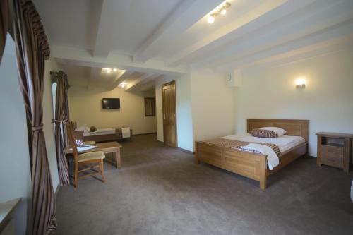 una camera da letto con un letto, una scrivania e una sedia di Hotel Stary Młyn a Suchedniów