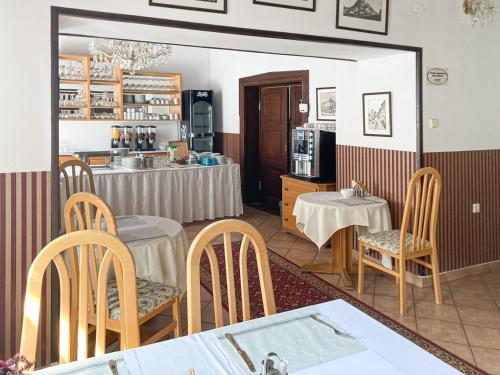 a restaurant with tables and chairs and a kitchen at Hotel Salamander - Garni in Banská Štiavnica