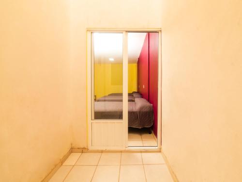 a bedroom with a mirror and a bed in a room at Hotel Santa Cruz, San Juan de los Lagos in San Juan de los Lagos