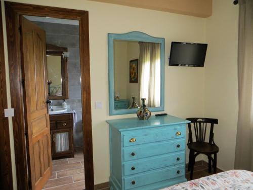 a bedroom with a blue dresser and a mirror at Casa Rural El Remolón in Piñuécar