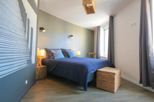 ein Schlafzimmer mit einem blauen Bett und einem Fenster in der Unterkunft Les Champs, T2 hypercentre chic et cosy Wifi par SOVALFI in Saint-Étienne