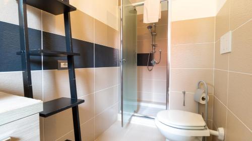 a bathroom with a toilet and a glass shower at Spapparra B&B in Càbras