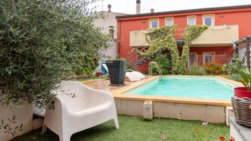 a swimming pool in the backyard of a house with a chair at Spapparra B&B in Càbras